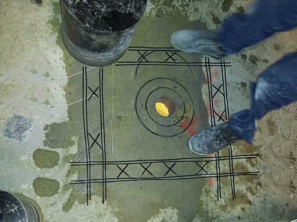 Contractor safely drilling concrete with marked safe zones visible from GPR scan